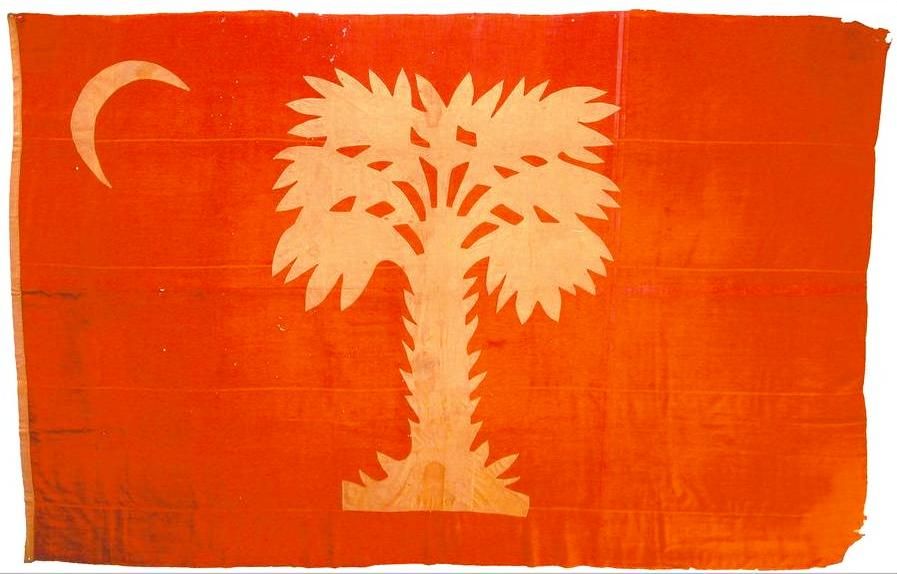 Faded red silk flag bearing a white palmetto tree and a white crescent in the upper corner
